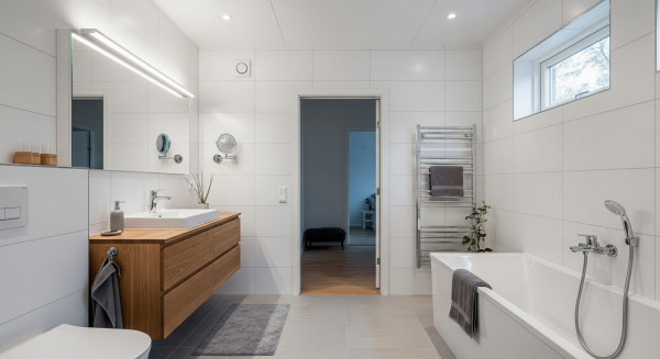 Ett helt vitkaklat nyrenoverat badrum efter badrumsrenovering Malmö