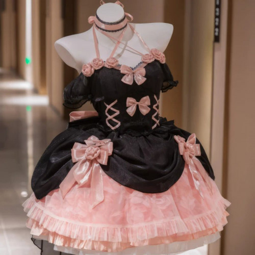 Black dress with pink ruffled skirt layers and pink ribbon bows, shown on a dress form