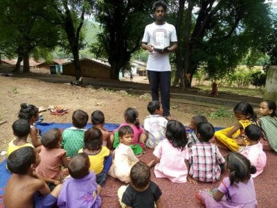 KKC kids listeing to exciting bible stories from the teacher Manasha