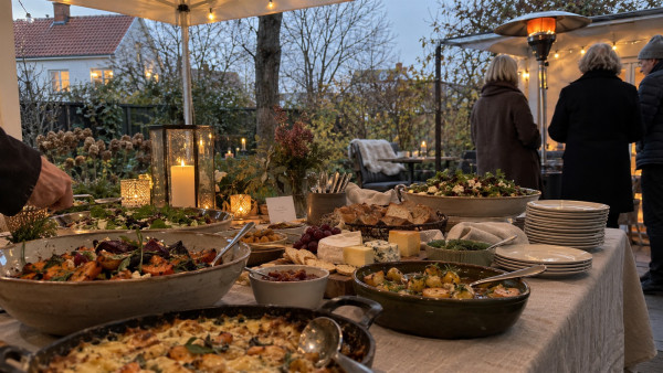 Buffé med cateringrätter under partytält i trädgården en novemberkväll