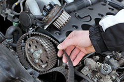 En man på Supreme Autoservice visar upp en kamrem i Malmö