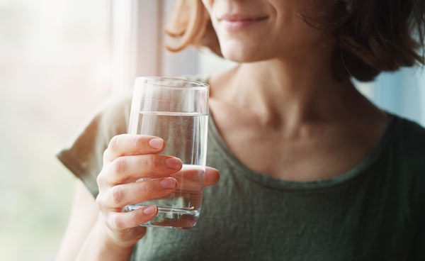 kvinna med muntorrhet som dricker vatten